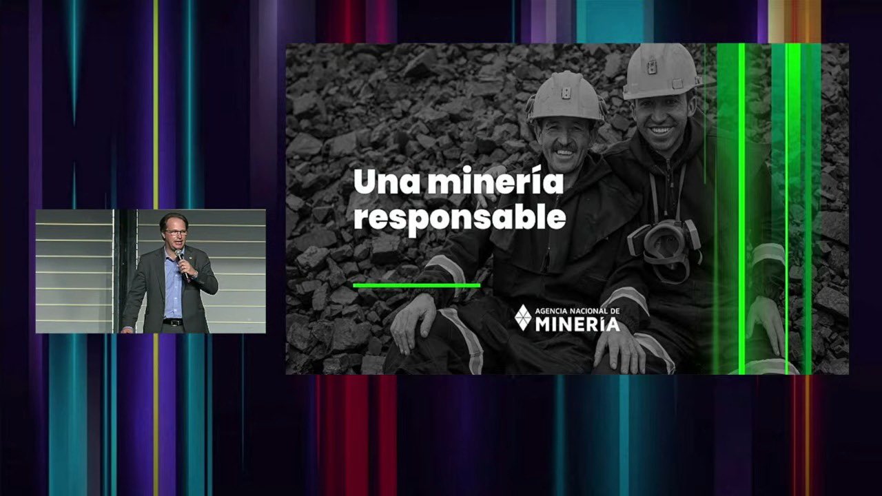 imagen del presidente realizando una presentacion con  agarrando un microfono con su mano izquierda y una diapositiva a su lado con dos mineros y un texto que dice  una mineria responsable.